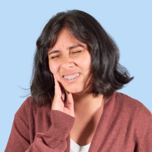 Young Latina woman frowning in pain caused by braces